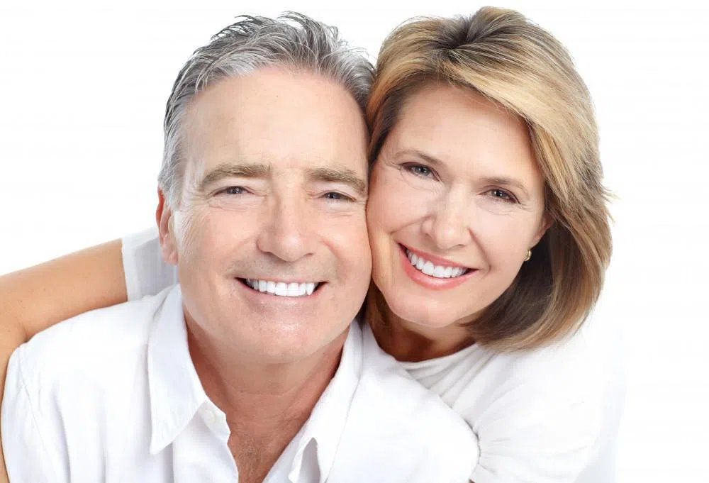 Aged couple smiling and looking at camera