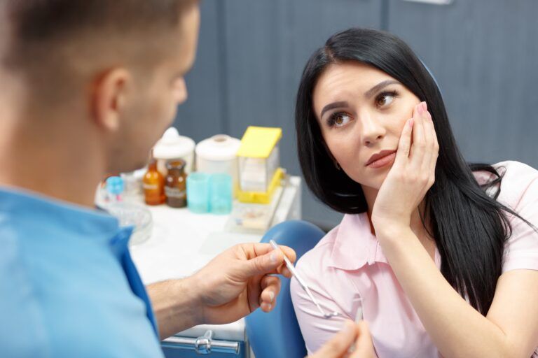 woman with tooth pain sitting in dental chair