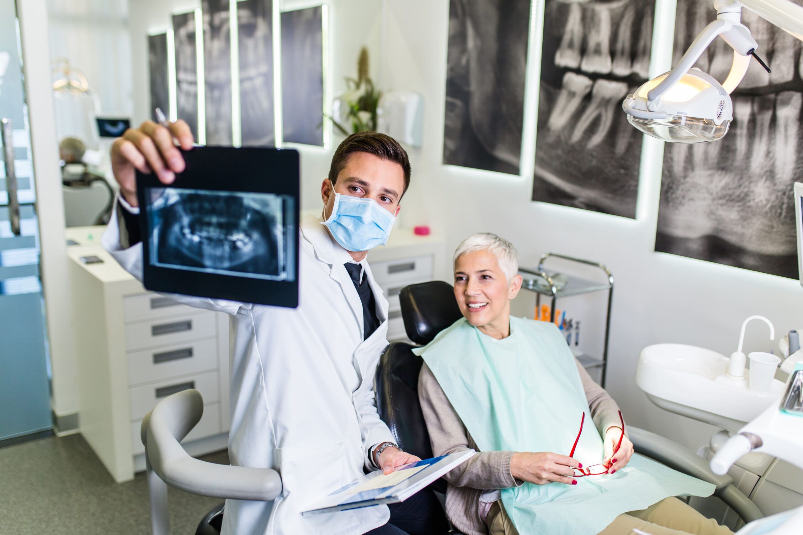 male dentist showing female patient dental x-ray
