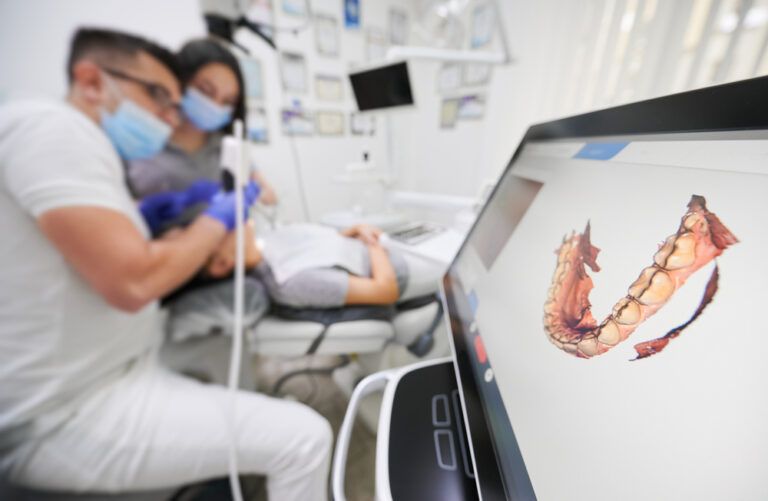 Dentist scanning patient's teeth with modern scanning machine
