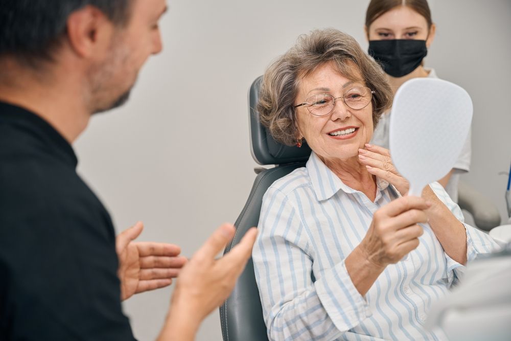 Pensioner at a dentists appointment looks at her teeth in the mirror