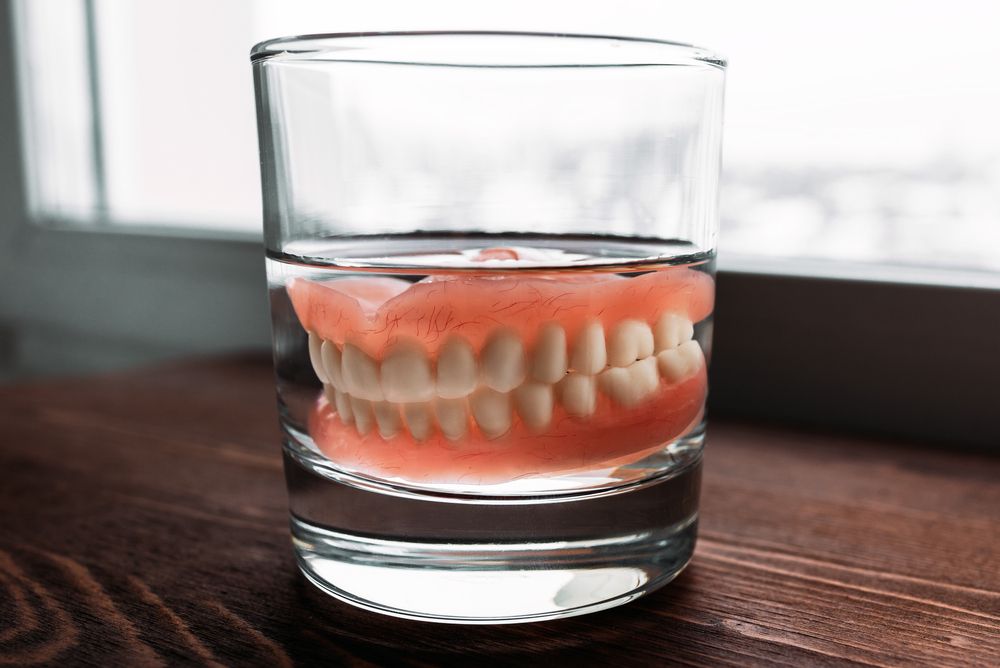 A Denture In A Glass Of Water. Dental Prosthesis Care.