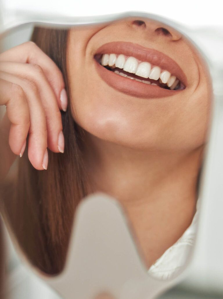 Happy young woman smiling checking out her perfect healthy teeth