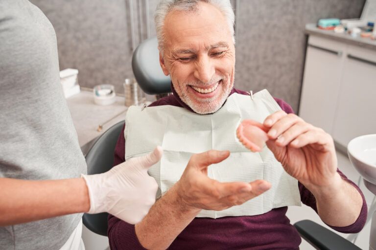 Cropped View Of The Dentist Showing dentures