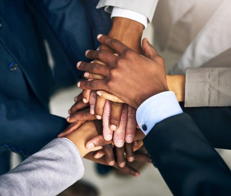 group of businesspeople joining their hands together in unity
