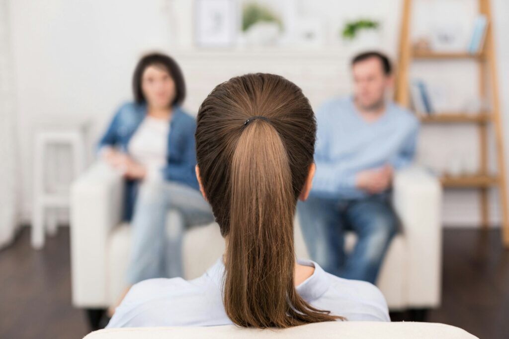 A person talking to a couple sitting