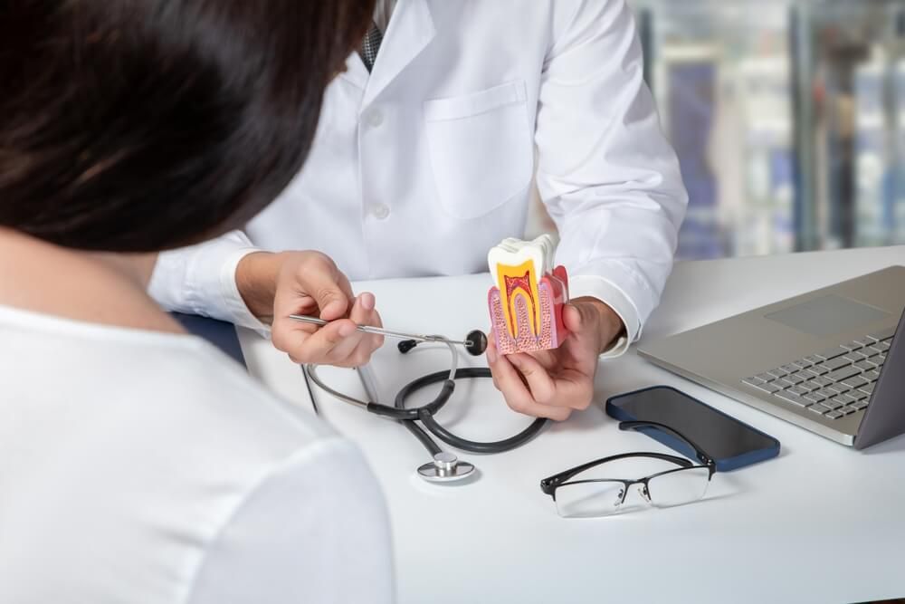 Doctor consulting a female patient about dental diseases in the office.