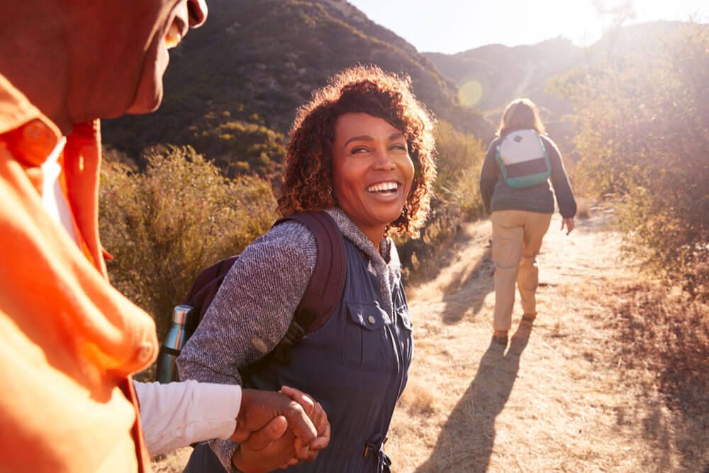 Group Of Senior Friends Go Hiking In Countryside Together