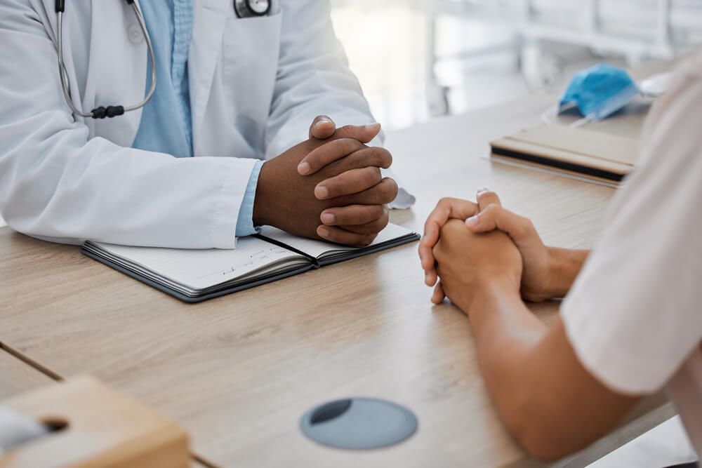 Doctor talking to patient at a desk at the hospital