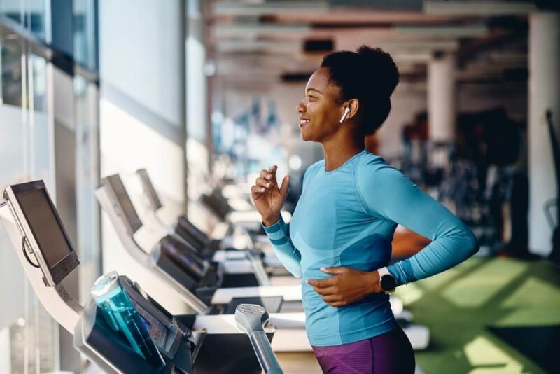 Happy African American athlete jogging on treadmill