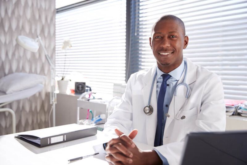 Portrait Of Smiling Male Doctor Wearing White Coat