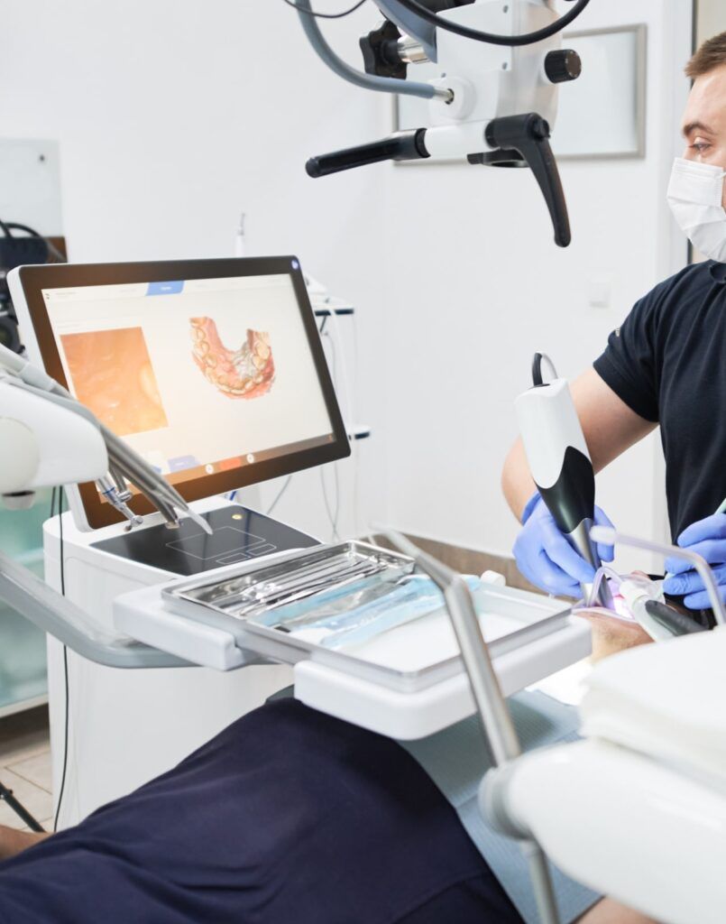 Dentist scanning patient's teeth with modern machine