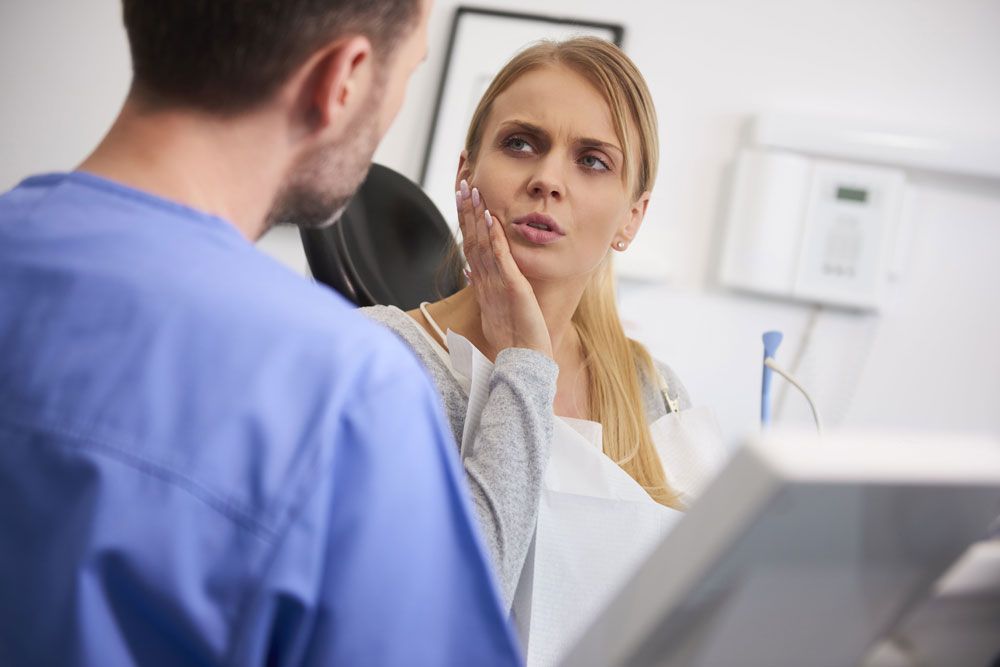 Woman at dental clinic having toothache