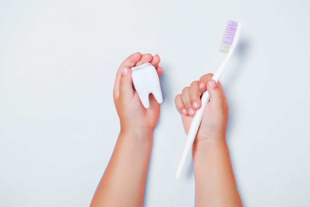 Kid holding toothbrush