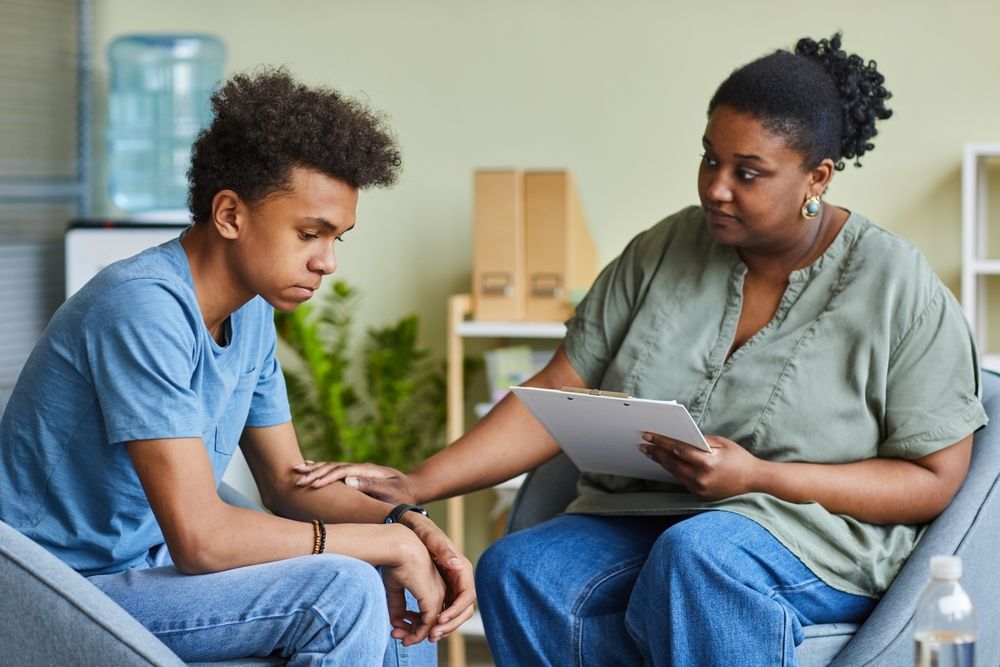 African Psychologist Supporting Depressed Teenage Boy