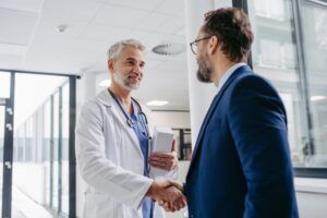 Pharmaceutical Sales Representative Presenting New Medication To Doctor