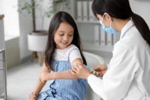 Little Asian Girl Receiving Vaccine In Clinic