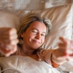 lady stretching arms after sleep and enjoying morning